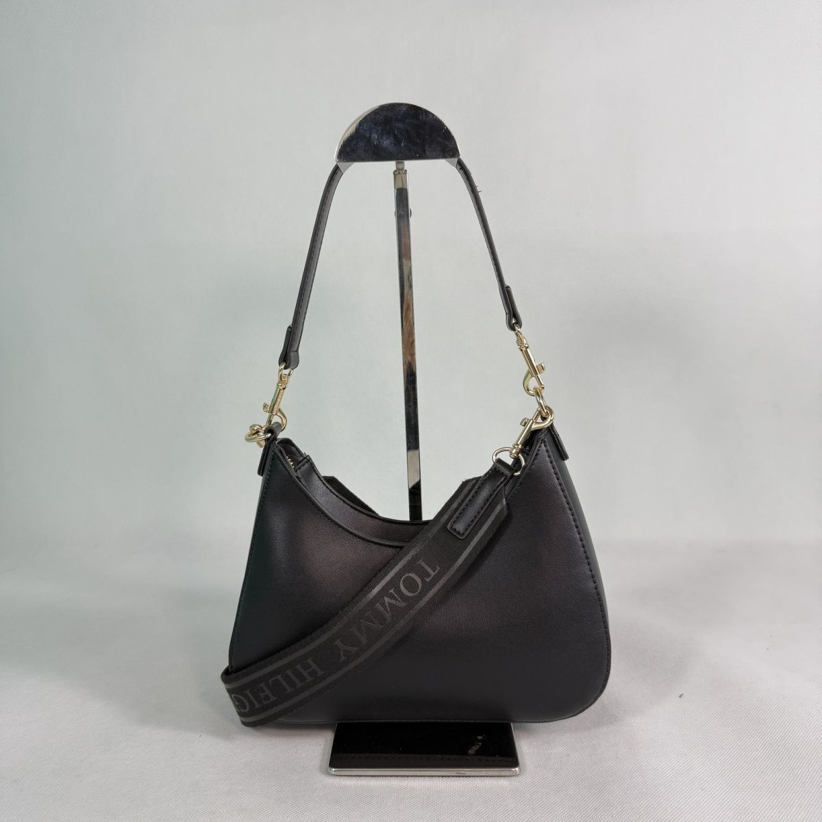 Tommy Hilfiger – TH მონოგრამითა და ნახევრადმთვარისებური ფორმით გაფორმებული ტრენდული ჩანთა thumbnail