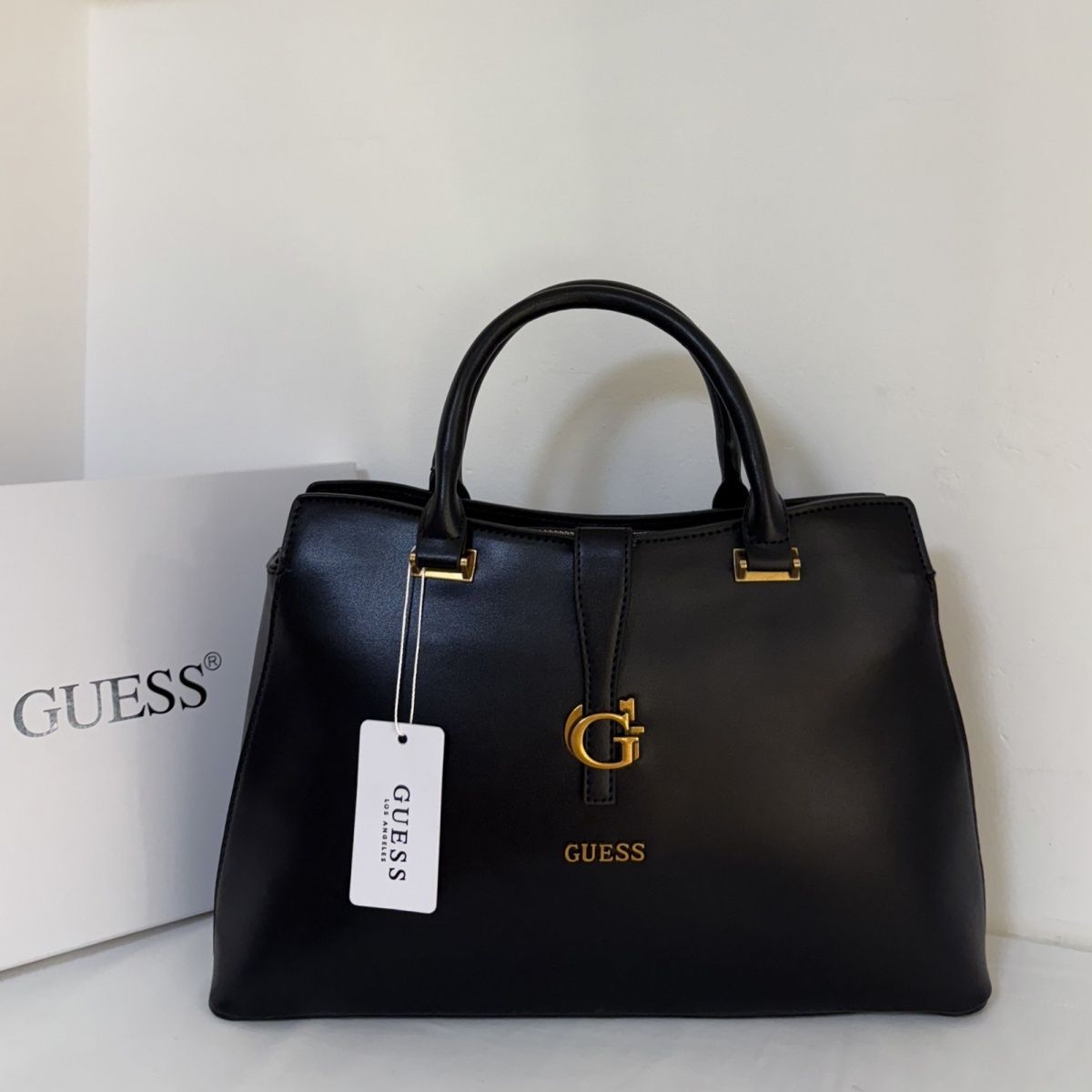 Guess – G მონოგრამითა და მეტალის ლოგოთი გაფორმებული ტრენდული ხელჩანთა