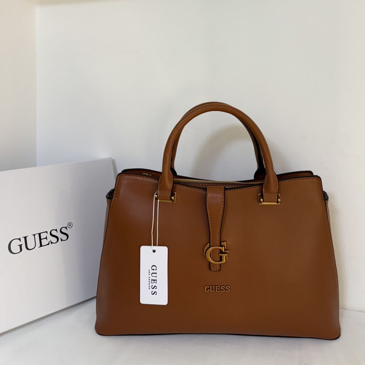 Guess – G მონოგრამითა და მეტალის ლოგოთი გაფორმებული ტრენდული ხელჩანთა