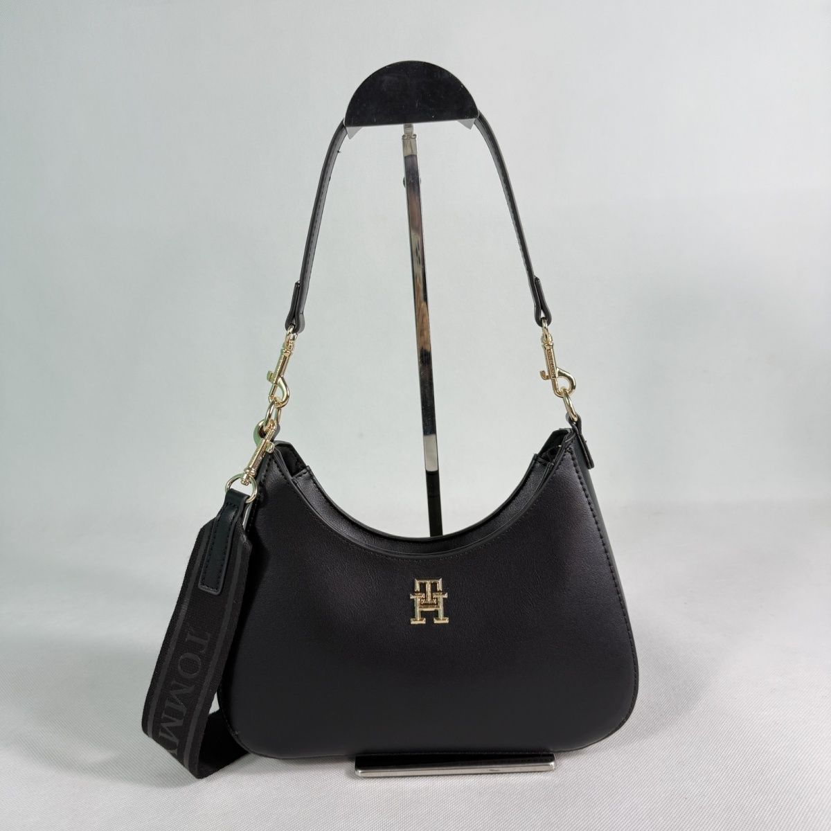 Tommy Hilfiger – TH მონოგრამითა და ნახევრადმთვარისებური ფორმით გაფორმებული ტრენდული ჩანთა thumbnail