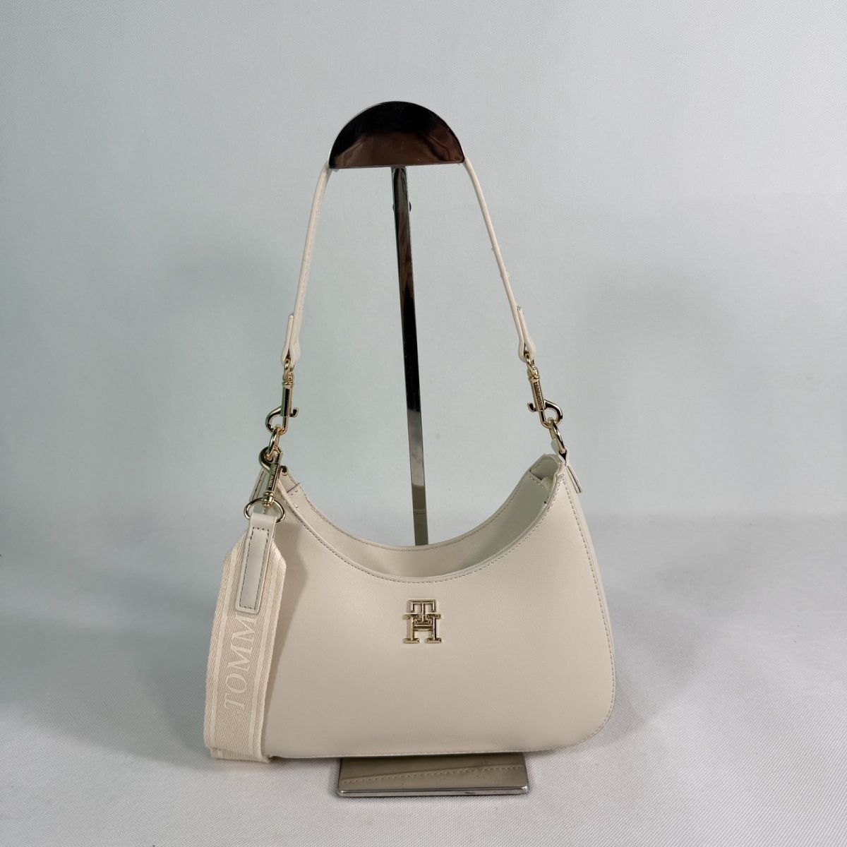 Tommy Hilfiger – TH მონოგრამითა და ნახევრადმთვარისებური ფორმით გაფორმებული ტრენდული ჩანთა